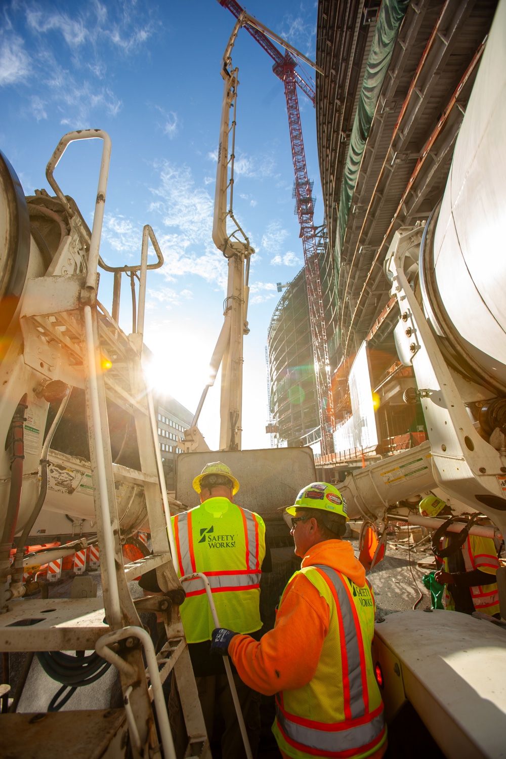 Workers on job site working concrete mixer trucks