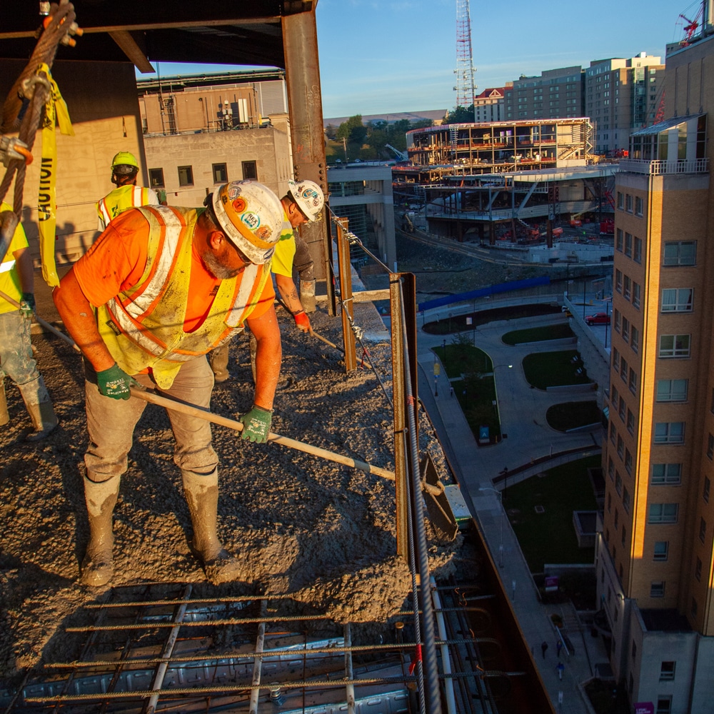 Castle Builders worker spreading concrete on a skyscraper site
