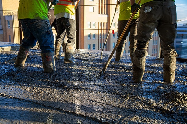 workers spreading concrete in skyscraper