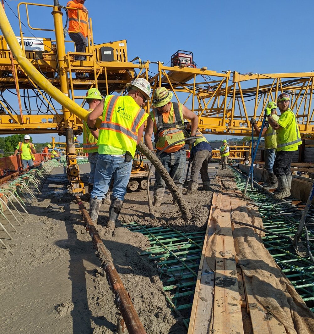 Workers pouring concrete on job site