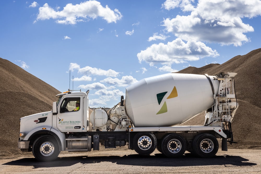 Castle Builder mixing truck parked in front of piles of mix