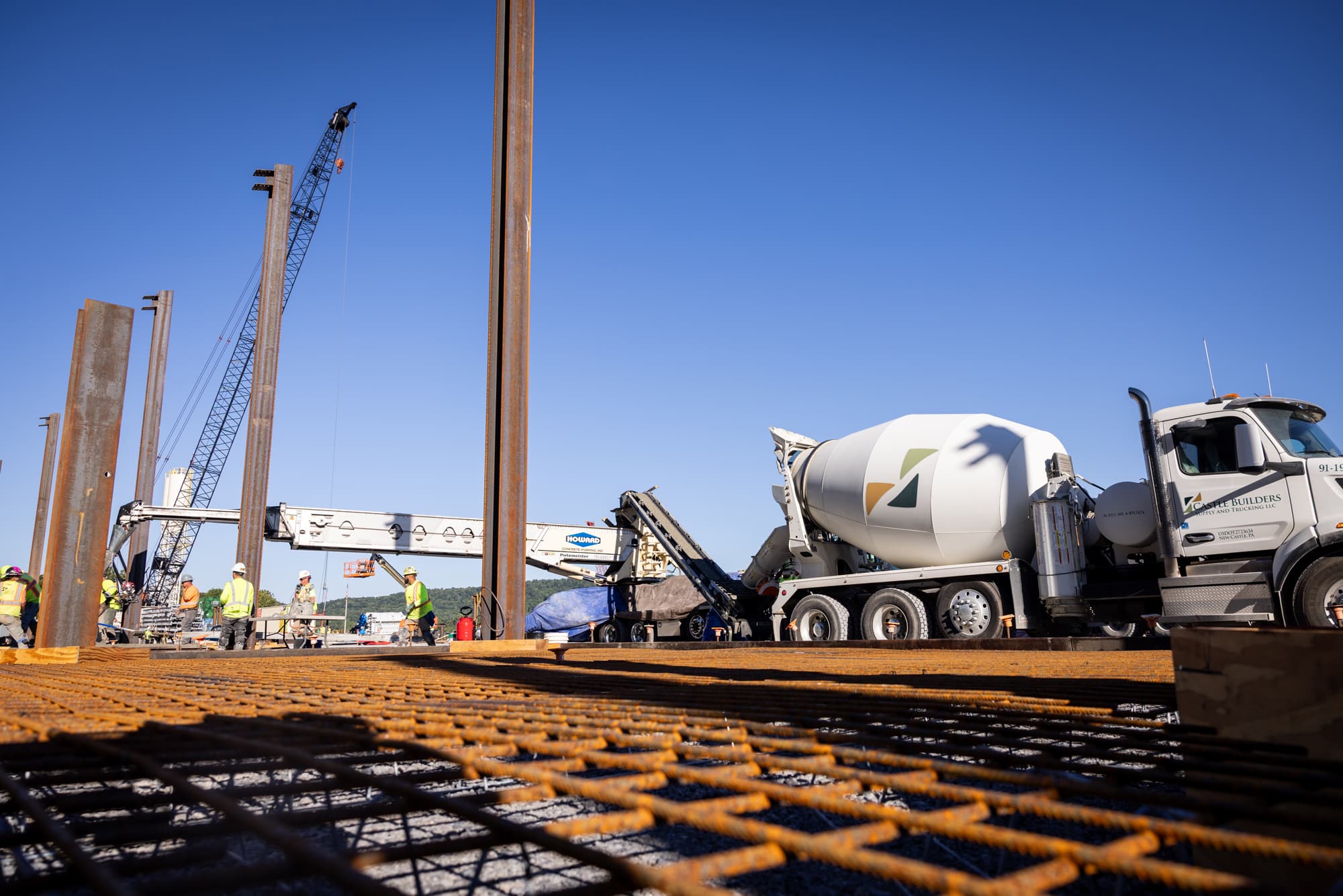 female team member in construction yellow smiling in front of a road closed sign